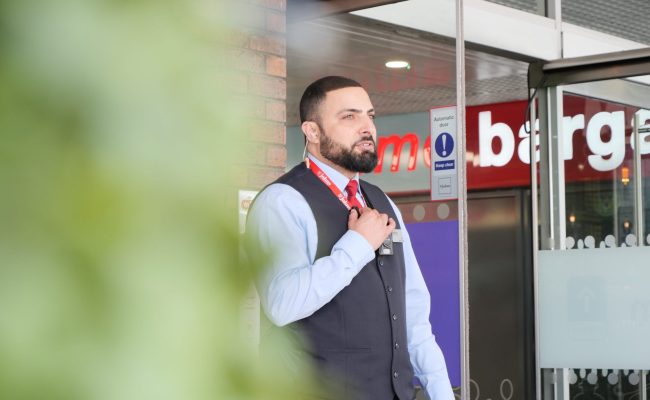 Security officer welcoming shoppers at a retail destination