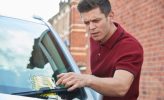 Frustrated Male Motorist Looking At Parking Ticket