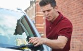 Frustrated Male Motorist Looking At Parking Ticket